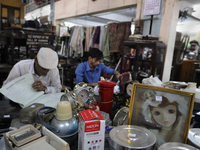 Md Omar(L) and Azharuddin(R) a young recent recruit busy at busy entering information on the log book for next day's auction at The Russell...