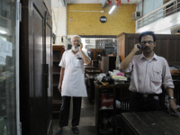 Ayub Mallik (L) and Sheikh Samsuddinan ( R) talking over phone informing regular customers about tomorrow's auction items at The Russell Exc...