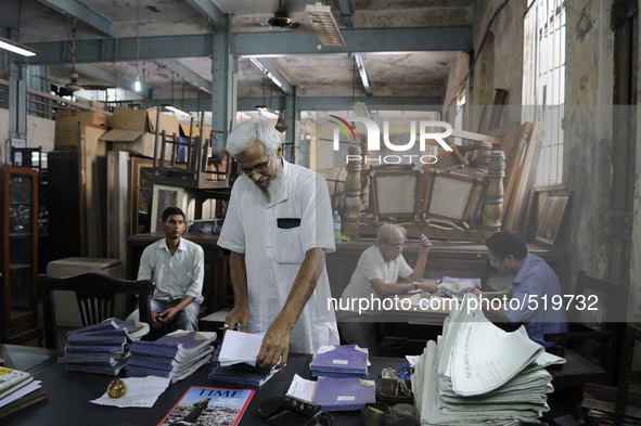 Ayub Mallik (M) searching for "cash memo" while sellers on the back are waiting to get paid for their sold items at The Russell Exchange on...