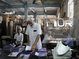 Ayub Mallik (M) searching for "cash memo" while sellers on the back are waiting to get paid for their sold items at The Russell Exchange on...