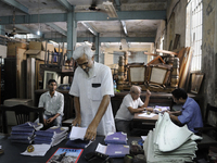 Ayub Mallik (M) searching for "cash memo" while sellers on the back are waiting to get paid for their sold items at The Russell Exchange on...