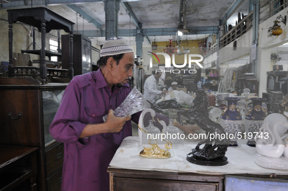 Mr. Yakub who is a supplier cleaning items on Saturday a day prior to the sunday auction on 4th April , 2015 in Kolkata, India.The Russell E...