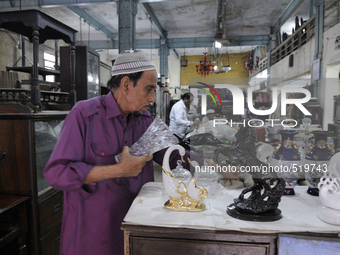 Mr. Yakub who is a supplier cleaning items on Saturday a day prior to the sunday auction on 4th April , 2015 in Kolkata, India.The Russell E...