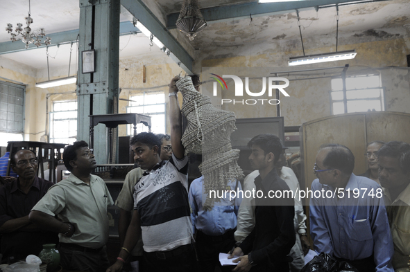 Vinod - A porter at The Russell Exchange showing off an item to open up bids during the Auction at The Russell Exchange on 5th April , 2015...