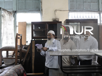 Mr.Riyaz (L) along with his associates looking through the check list ( the piece of computer generated piece of paper used every week) duri...