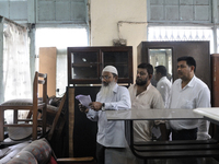 Mr.Riyaz (L) along with his associates looking through the check list ( the piece of computer generated piece of paper used every week) duri...