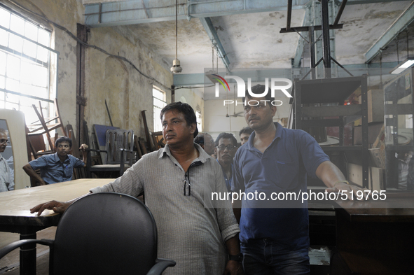 Mr. Ahmed( L) a regular buyer of furniture standing along with Kapil- A porter at The Russell Exchange watching closely the furniture auctio...