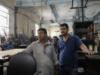 Mr. Ahmed( L) a regular buyer of furniture standing along with Kapil- A porter at The Russell Exchange watching closely the furniture auctio...