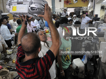 Munna (guy with red and black t-shirt) an electronic dealer lifting an electronics item for others to see during an  auction at The Russell...