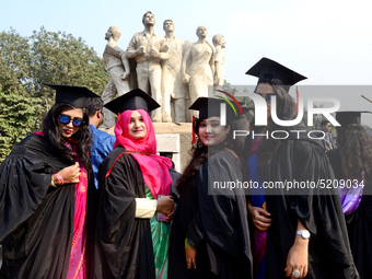 A group of graduates expressing their delight in front of the sculpture Raju at TSC area, on the 52th convocation of the students of Dhaka U...