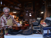 Former theatre actor and long time artist and luthier, Jozef Gmyrek (age 71), tunes a guitar in his workshop.
His work is not a job but a pa...