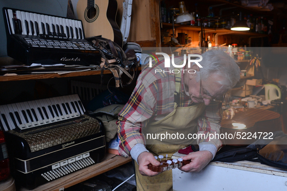 Former theatre actor and long time artist and luthier, Jozef Gmyrek (age 71), tunes a guitar in his workshop. 
His work is not a job but a p...