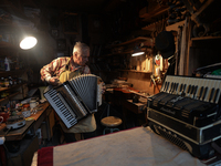 Former theatre actor and long time artist and luthier, Jozef Gmyrek (age 71), tunes an accordion in his workshop.     
His work is not a job...