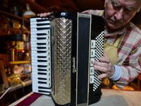 Former theatre actor and long time artist and luthier, Jozef Gmyrek (age 71), tunes an accordion in his workshop.    
His work is not a job...