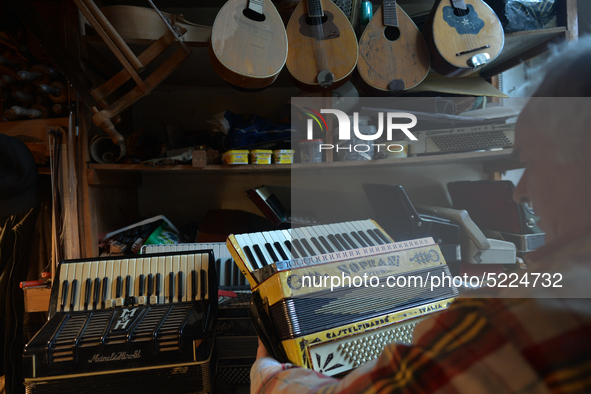 Former theatre actor and long time artist and luthier, Jozef Gmyrek (age 71), holds an antic Settimio Soprani accordion, inside his workshop...