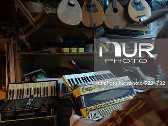 Former theatre actor and long time artist and luthier, Jozef Gmyrek (age 71), holds an antic Settimio Soprani accordion, inside his workshop...