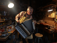 Former theatre actor and long time artist and luthier, Jozef Gmyrek (age 71), tunes an accordion in his workshop.     
His work is not a job...