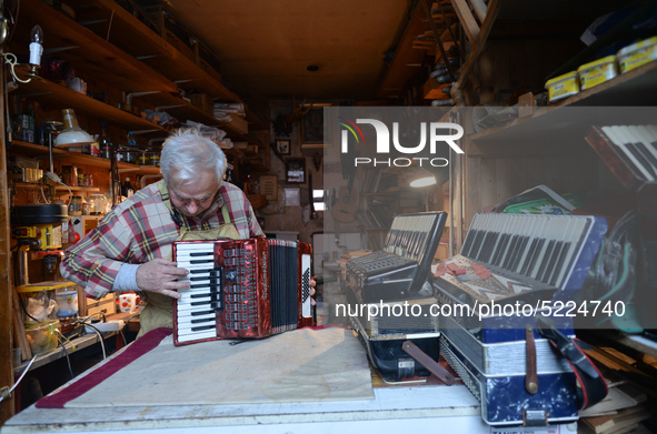 Former theatre actor and long time artist and luthier, Jozef Gmyrek (age 71), tunes an accordion in his workshop.   
His work is not a job b...