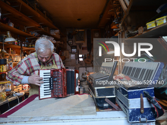 Former theatre actor and long time artist and luthier, Jozef Gmyrek (age 71), tunes an accordion in his workshop.   
His work is not a job b...