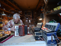 Former theatre actor and long time artist and luthier, Jozef Gmyrek (age 71), tunes an accordion in his workshop.   
His work is not a job b...