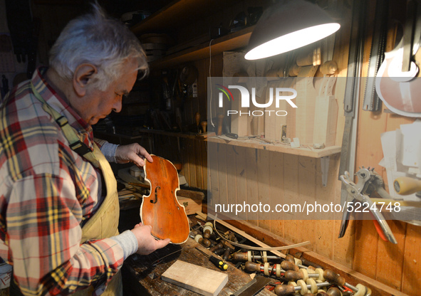 Former theatre actor and long time artist and luthier, Jozef Gmyrek (age 71), repairs a violin in his workshop.  
His work is not a job but...