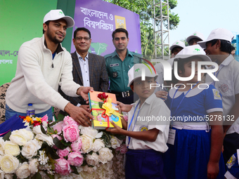 Bangladeshi Cricketer Shakib Al Hasan (L) distributing textbooks among students at the Dhaka University sports ground as the government kick...