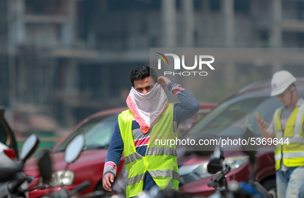 Indian and Sri Lankan construction workers walk out of a mega-construction site wearing  face masks following  the  Corona virus outbreak in...