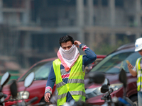 Indian and Sri Lankan construction workers walk out of a mega-construction site wearing  face masks following  the  Corona virus outbreak in...