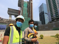 Indian and Sri Lankan construction workers walk out of a mega-construction site wearing  face masks following  the  Corona virus outbreak in...