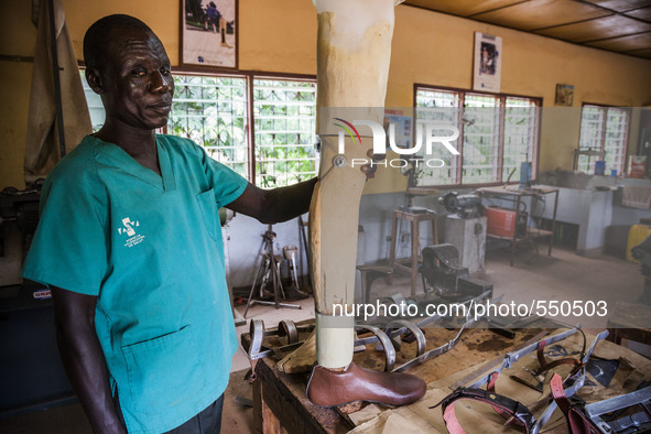 A local worker holds a prosthetic leg in the Bombuaka workshop of prostheses, Togo. 