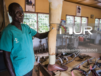 A local worker holds a prosthetic leg in the Bombuaka workshop of prostheses, Togo. (