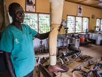 A local worker holds a prosthetic leg in the Bombuaka workshop of prostheses, Togo. (