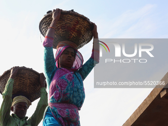 Bangladeshi laborers unload coal from boats  ahead of International Women's Day at the River Turag in Dhaka, Bangladesh, on March 7, 2020. (