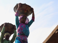 Bangladeshi laborers unload coal from boats  ahead of International Women's Day at the River Turag in Dhaka, Bangladesh, on March 7, 2020. (