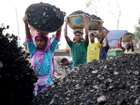 Bangladeshi laborers unload coal from boats  ahead of International Women's Day at the River Turag in Dhaka, Bangladesh, on March 7, 2020. (