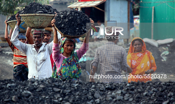 Bangladeshi laborers unload coal from boats  ahead of International Women's Day at the River Turag in Dhaka, Bangladesh, on March 7, 2020. 