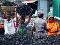 Bangladeshi laborers unload coal from boats  ahead of International Women's Day at the River Turag in Dhaka, Bangladesh, on March 7, 2020. (