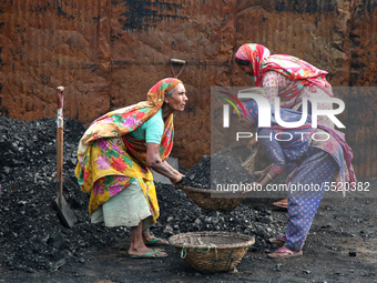 Bangladeshi laborers unload coal from boats  ahead of International Women's Day at the River Turag in Dhaka, Bangladesh, on March 7, 2020. (