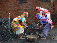 Bangladeshi laborers unload coal from boats  ahead of International Women's Day at the River Turag in Dhaka, Bangladesh, on March 7, 2020. (