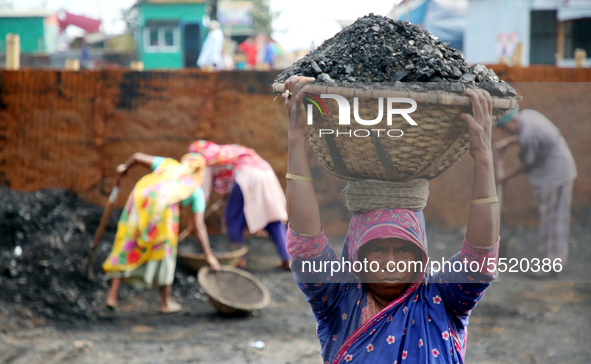 Bangladeshi laborers unload coal from boats  ahead of International Women's Day at the River Turag in Dhaka, Bangladesh, on March 7, 2020. 