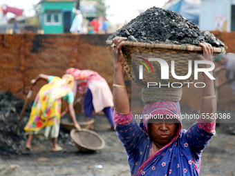 Bangladeshi laborers unload coal from boats  ahead of International Women's Day at the River Turag in Dhaka, Bangladesh, on March 7, 2020. (