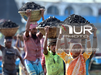 Bangladeshi laborers unload coal from boats  ahead of International Women's Day at the River Turag in Dhaka, Bangladesh, on March 7, 2020. (