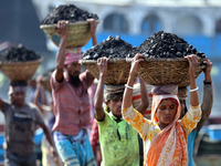 Bangladeshi laborers unload coal from boats  ahead of International Women's Day at the River Turag in Dhaka, Bangladesh, on March 7, 2020. (