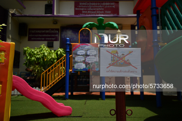 An empty playground with sign temporarily out of service in the school due coronavirus outbreak during the semester off at Wat Mahannapharam...