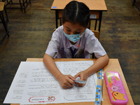 A elementary school student wears a face mask as a preventive measure in a class is a demonstration of learning amid the pandemic of the cor...