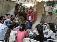 A Palestinian school girl Fajr Hmaid, 13, teaches her neighbours' children an Arabic language lesson as schools are shut due to the coronavi...