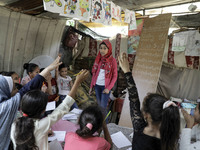 A Palestinian school girl Fajr Hmaid, 13, teaches her neighbours' children an Arabic language lesson as schools are shut due to the coronavi...