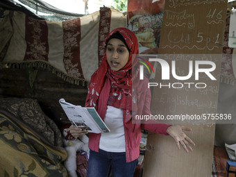 A Palestinian school girl Fajr Hmaid, 13, teaches her neighbours' children an Arabic language lesson as schools are shut due to the coronavi...