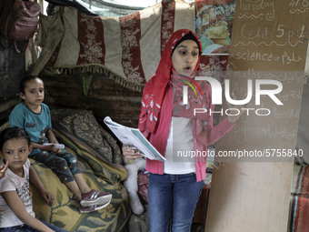 A Palestinian school girl Fajr Hmaid, 13, teaches her neighbours' children an Arabic language lesson as schools are shut due to the coronavi...