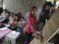 A Palestinian school girl Fajr Hmaid, 13, teaches her neighbours' children an Arabic language lesson as schools are shut due to the coronavi...